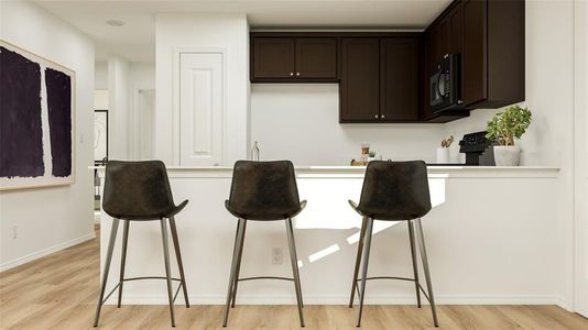 Kitchen featuring a breakfast bar, dark brown cabinets, and light wood-type flooring