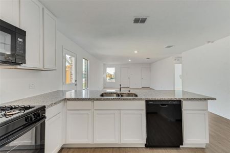 Kitchen featuring light hardwood / wood-style flooring, white cabinets, black appliances, and sink