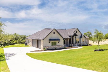 View of front of property featuring a garage and a front lawn