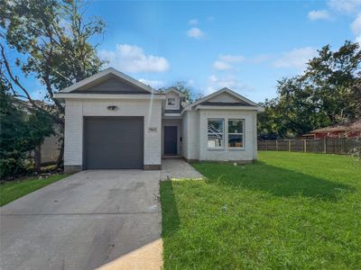 Single story home with a garage and a front lawn