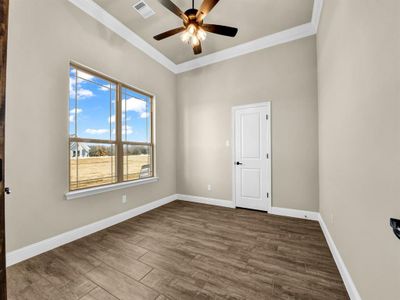 Spare room featuring ornamental molding, ceiling fan, and dark hardwood / wood-style flooring