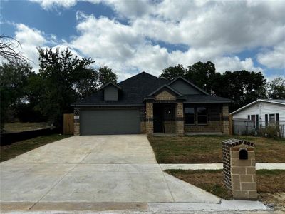 View of front of house with a garage and a front yard