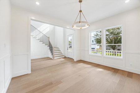 Step through the front porch into an inviting foyer featuring soaring 20-foot ceilings, expansive windows that flood the space with natural light, and beautiful wood floors that add warmth and elegance to the entryway.  Photos as of 11/5/202