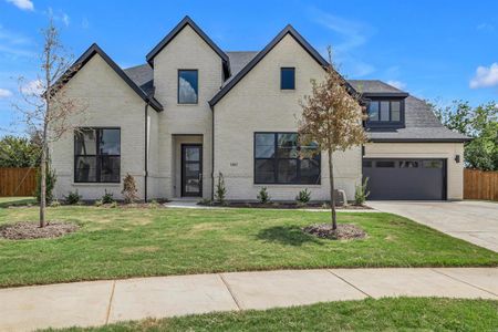 View of front of house with a garage and a front lawn