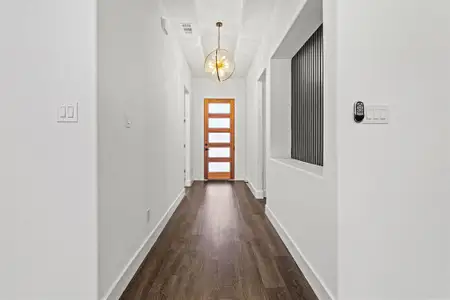 Doorway to outside with visible vents, a chandelier, dark wood finished floors, and baseboards