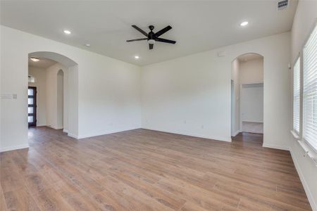 Spare room featuring ceiling fan, a wealth of natural light, and light hardwood / wood-style floors