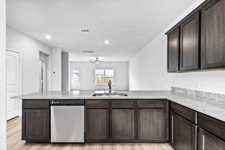 Kitchen with sink, stainless steel dishwasher, and kitchen peninsula