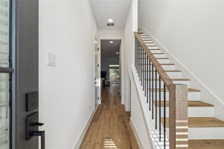 Bright and inviting entryway with sleek modern finishes and a stylish staircase leading to the upper level.