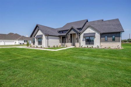 View of front of house featuring a front lawn and a garage