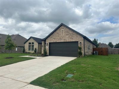 View of front of home featuring a garage, central AC, and a front lawn