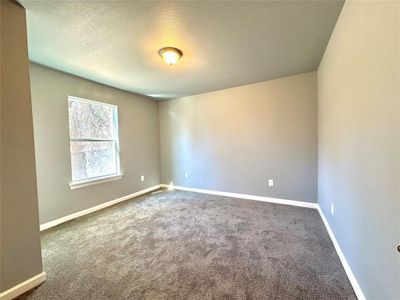 Empty room featuring carpet flooring and a textured ceiling