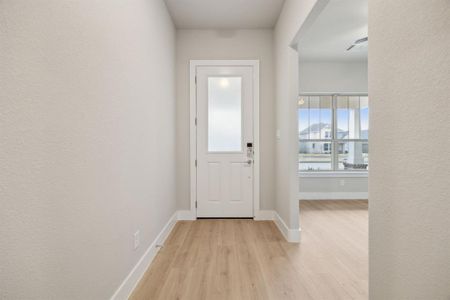 Doorway with light hardwood / wood-style floors