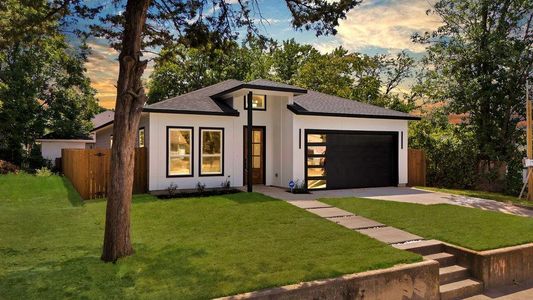 View of front of house featuring a garage and a yard