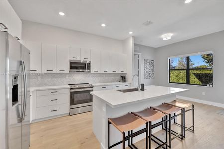 Bright and large white kitchen w/ counter seating and room for eat in kitchen table