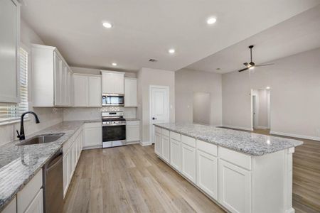 Seamlessly integrated into the overall design scheme of the home, the open kitchen island fosters a sense of continuity and harmony between the kitchen and family room, enhancing the flow of space and promoting a unified aesthetic appeal.