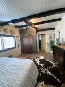 Bedroom featuring beamed ceiling and wood finished floors