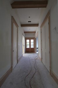 White oak double front doors, white oak ceiling beams and herringbone hardwoods welcome your guests in the entry foyer.