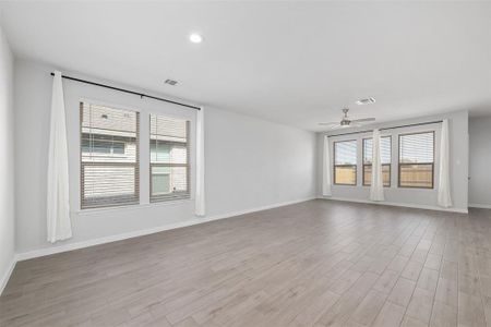 Empty room with ceiling fan and light wood-type flooring