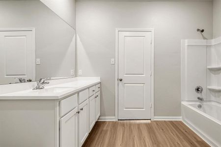 The en-suite primary bathroom has a shower/tub combo and a walk-in closet.