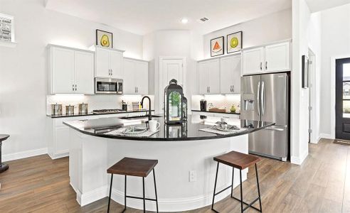 Kitchen featuring sink, white cabinets, a kitchen island with sink, and stainless steel appliances