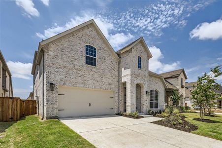 View of front facade featuring a garage and a front lawn