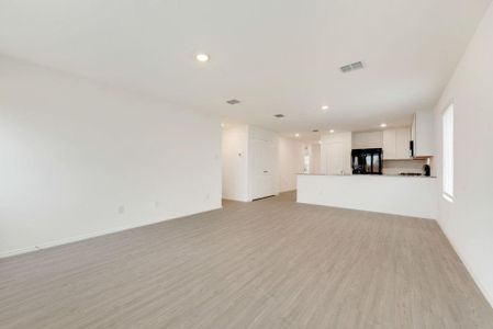 Unfurnished living room with light wood-style floors, baseboards, visible vents, and recessed lighting