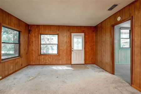 Spare room featuring wood walls and light colored carpet