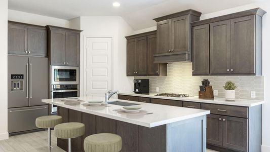 Kitchen with a sink, a kitchen breakfast bar, tasteful backsplash, stainless steel appliances, and dark brown cabinets