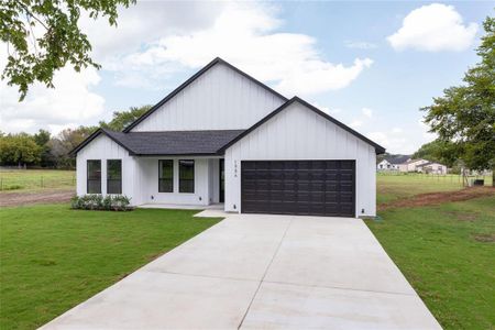 Modern farmhouse style home with a front yard and a garage