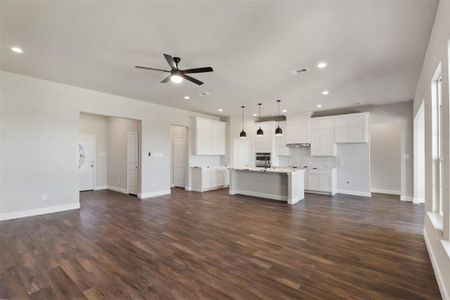 Unfurnished living room featuring dark hardwood / wood-style floors and ceiling fan