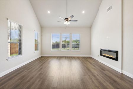 Unfurnished living room featuring ceiling fan, high vaulted ceiling, and dark hardwood / wood-style floors