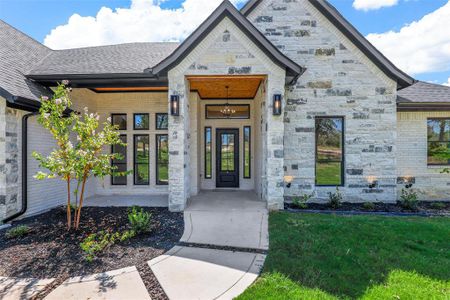 View of exterior entry featuring a lawn