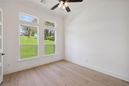 Empty room with ceiling fan, light hardwood / wood-style flooring, and crown molding