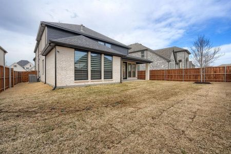 Back of property with a lawn, central AC, a fenced backyard, a shingled roof, and brick siding