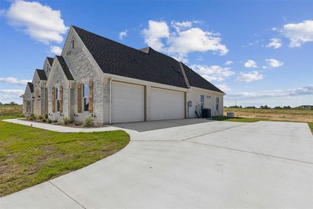 View of home's exterior featuring a yard, a garage, and central AC