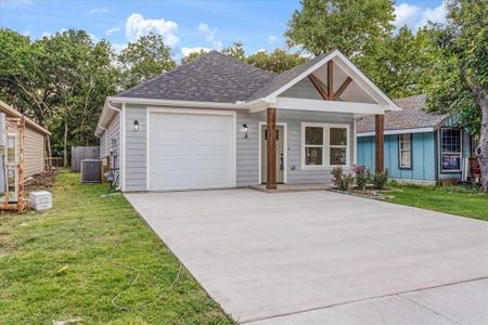 View of front facade featuring a garage, central AC unit, and a front lawn