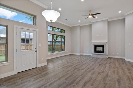 Entryway featuring ceiling fan, ornamental molding, hardwood / wood-style flooring, and a healthy amount of sunlight