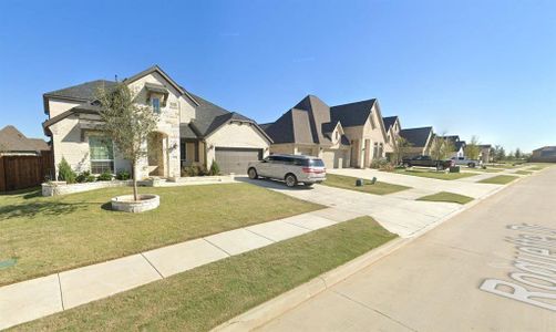 French country inspired facade with a garage and a front lawn