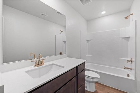 Full bathroom with toilet, wood finished floors, vanity, and shower / bathing tub combination