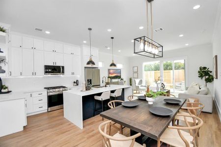 A sophisticated, modern kitchen featuring sleek stainless steel appliances, a striking waterfall island, and meticulously positioned lighting, elevating both style and functionality.