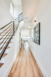 Hallway featuring a wealth of natural light and light hardwood / wood-style floors