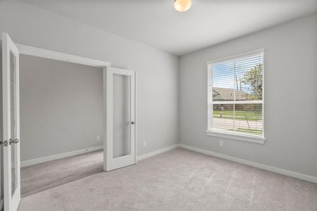 Quietly nestled in front of the home is the sophisticated home office. Featuring plush carpet, custom paint and large window with privacy blinds. Sample photo of completed home with similar floor plan. As-built interior colors and selections may vary.