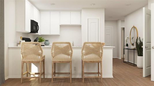 Kitchen featuring light wood-type flooring, a breakfast bar area, and white cabinets