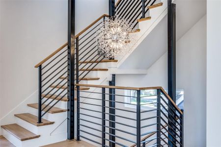 Staircase featuring hardwood / wood-style floors and a chandelier