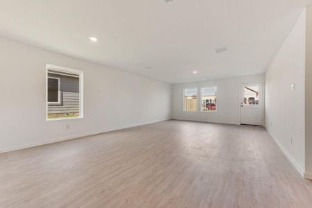 Unfurnished living room featuring light wood-style flooring, baseboards, and recessed lighting