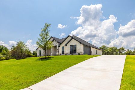 View of front of property featuring a garage and a front lawn