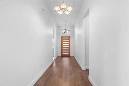 Corridor featuring a chandelier and dark hardwood / wood-style flooring