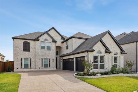 French country inspired facade with a front yard and a garage