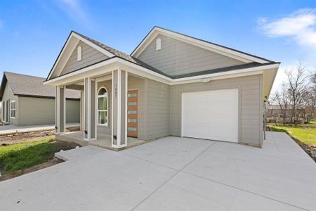 View of front of home featuring driveway, covered porch, an attached garage, and a shingled roof