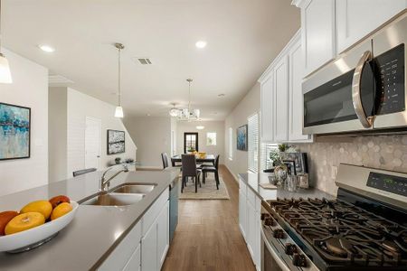 A chef’s dream kitchen! Featuring Silestone Quartz countertops, a walk-in pantry, and stainless steel appliances, this space is designed for both style and functionality. The open layout flows seamlessly into the living area.